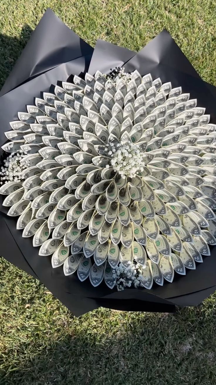 an umbrella made out of money sitting in the grass on top of it's side