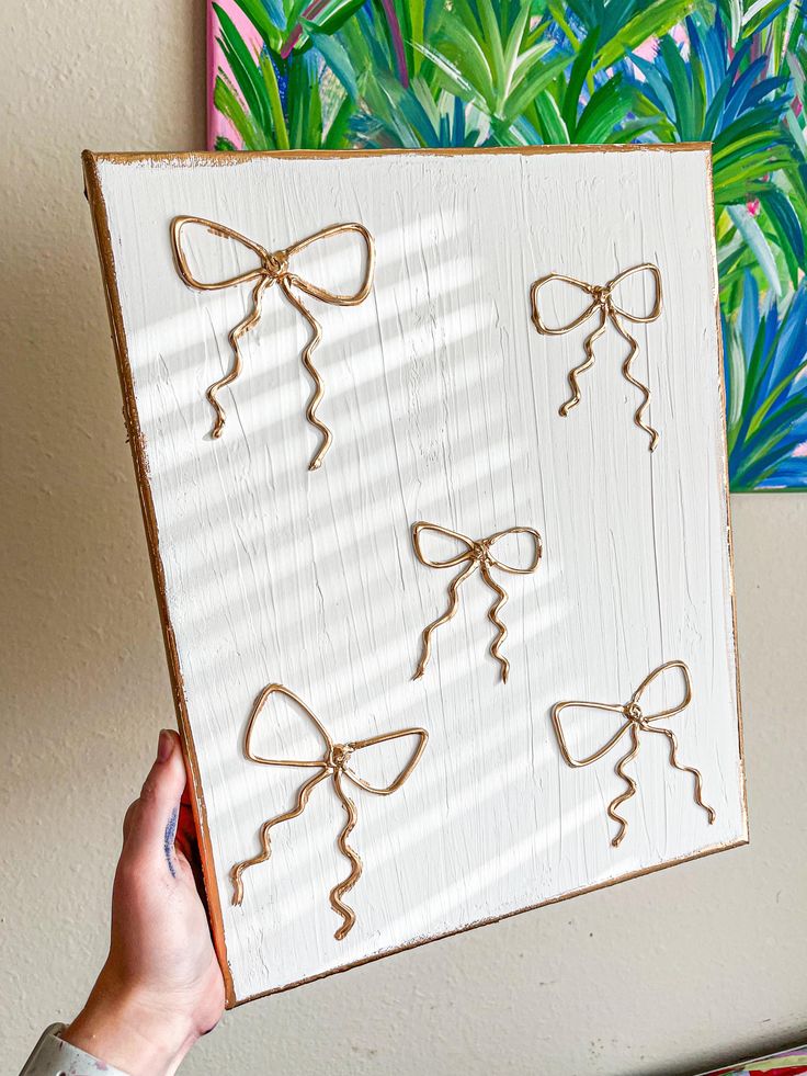 a person holding up a piece of wood with bows on it