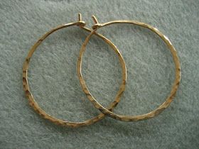 two large gold hoop earrings sitting on top of a carpet