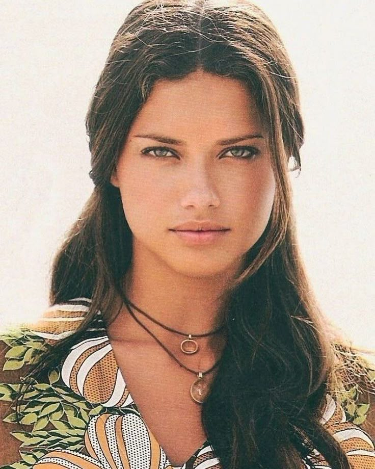 a woman with long hair wearing a necklace