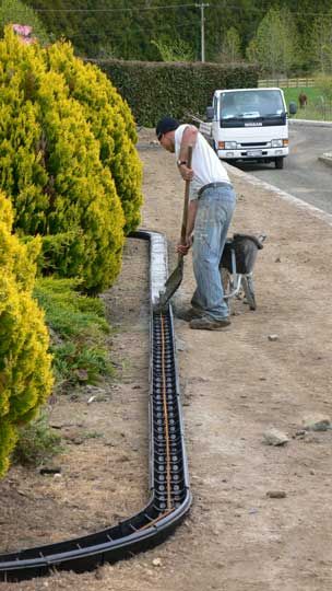 a man with a dog working on a train track next to some bushes and trees