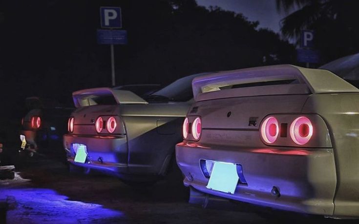 several cars parked next to each other at night