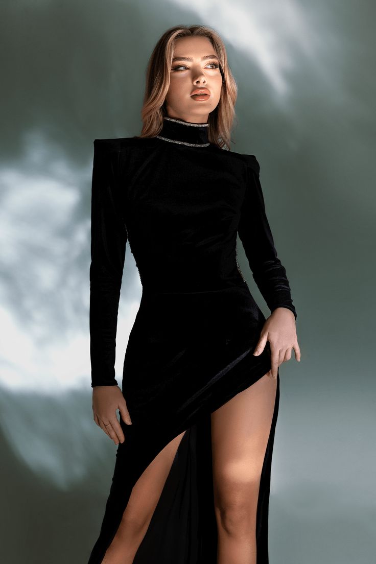 The Gaia Dress is a stunning and elegant piece of clothing that is perfect for any formal occasion. The dress is carefully handcrafted from high-quality velvet fabric, ensuring its softness and comfort on the skin. The long hemline adds an air of sophistication to the dress, while the open leg creates a sultry and alluring element that is sure to turn heads. The dress's standout features are the high neck and the sophisticated back design. The high neck adds a touch of elegance and class to the Fitted Dress With Back Opening For Gala, Knee-length Gown With Fitted Bodice, Formal Evening Dress With Back Opening, Party Gown With Side Slits, Fitted Evening Dress With Back Opening For Gala, Fitted Bodice Evening Dress With Side Slits For Party, Fitted Evening Dress With Back Opening, Fitted Evening Maxi Dress For Formal Occasions, Chic Velvet Mini Dress For Formal Occasions