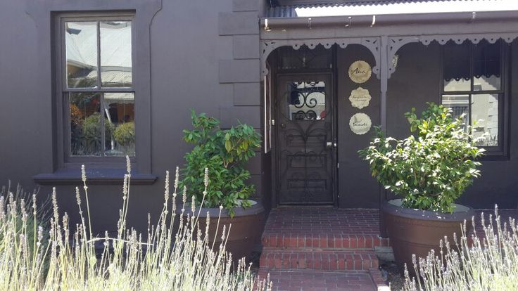 two potted plants sit outside the front door of a house