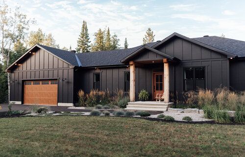 a black house with two garages on the front