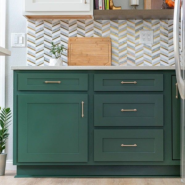 a kitchen with green cabinets and white walls