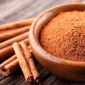 cinnamon sticks and powder in a wooden bowl