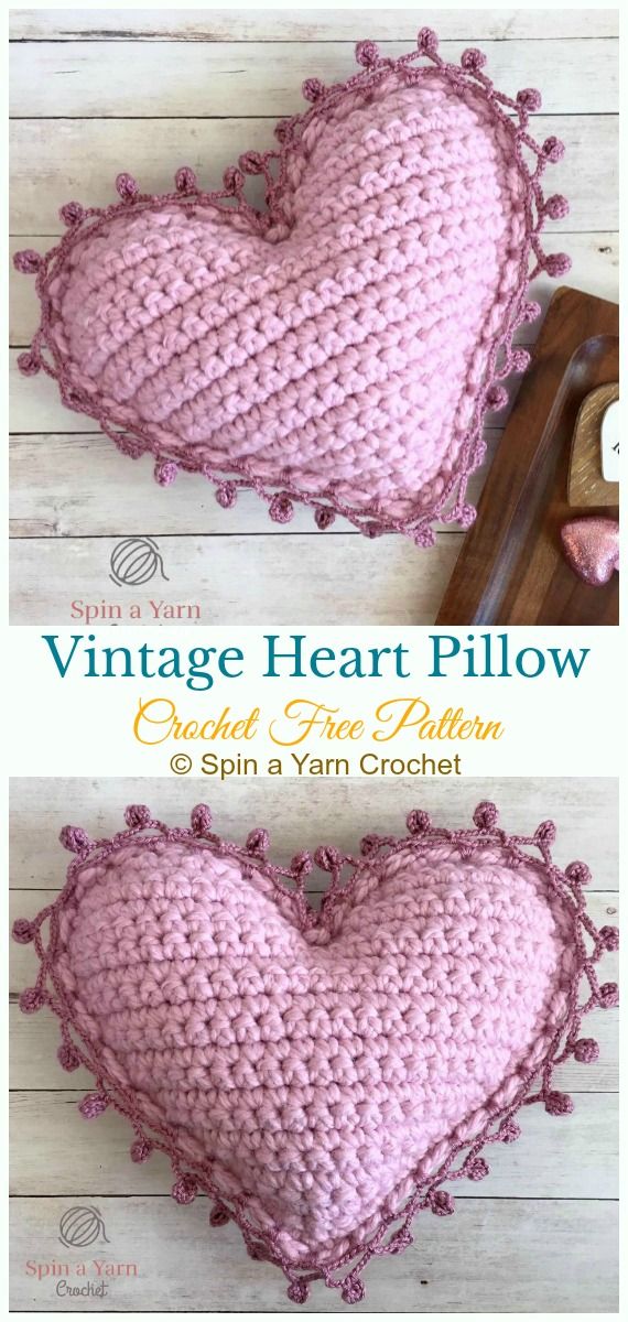 two pink crocheted heart pillows sitting on top of a wooden table next to each other