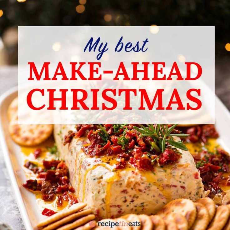 a white plate topped with cheese and crackers next to a christmas tree