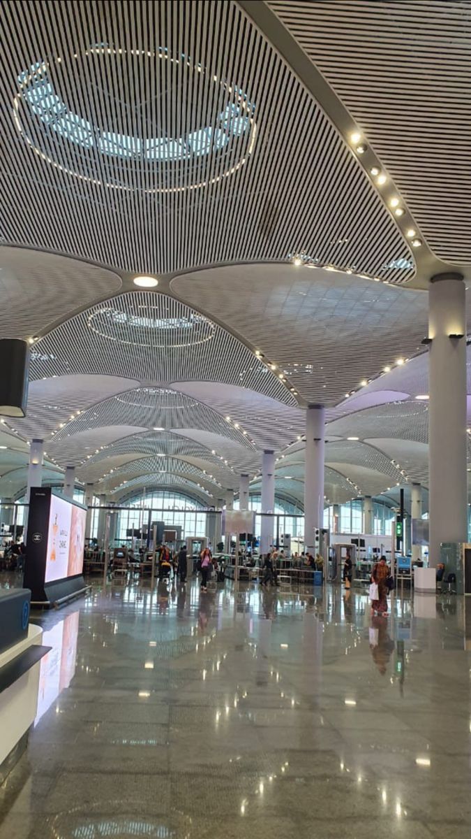 an airport terminal with people walking around