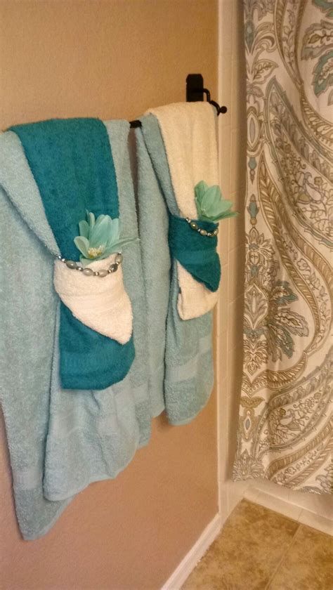 two towels hanging on the wall next to a shower