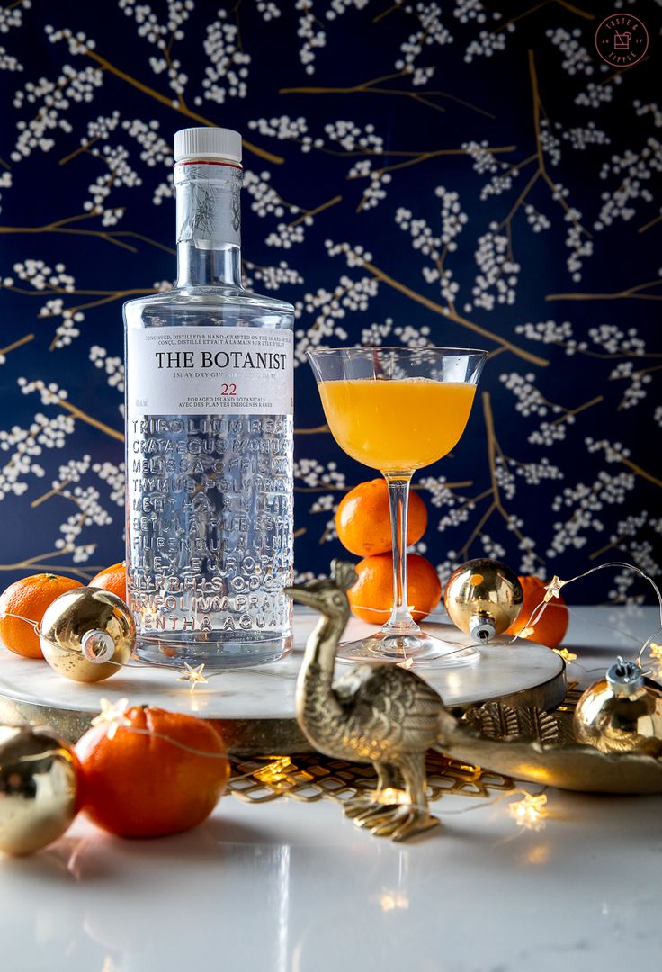 a bottle of the botanie gin on a table with oranges and christmas decorations