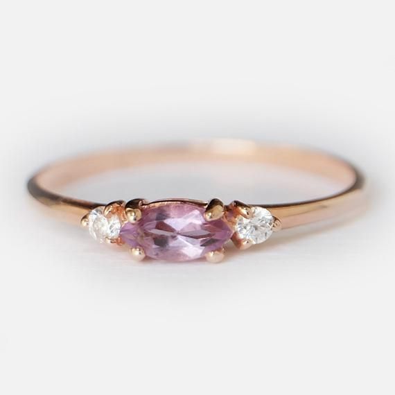 Engagement Ring Details14k Solid Rose Gold (Also available in White and Yellow Gold, Please select at checkout) 1.5mm (Approximate Band Width) Amethyst (Center Stone) Marquise 6X3mm (Center Stone Dimensions) 0.22 Carats (Average Center Stone Weight)Surrounding Diamond DetailsWhite Diamonds 0.06 Carats (Total Diamond Weight/ 2 Pcs.) SI-H (White Diamond) Brilliant CutRing can be resized from 3-10, Metal can be made in 14, 18K/ White, Yellow and Rose Gold.For custom order this ring with a different Topaz Wedding Ring, Gold Amethyst Ring, Ring Purple, Detailed Engagement Ring, Amethyst And Diamond Ring, Marquise Ring, Topaz Engagement Ring, Modern Engagement Rings, Amethyst Gold