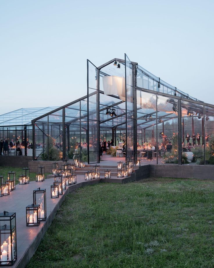 many candles are lit in front of a glass building