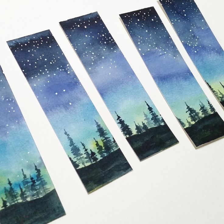 four watercolor bookmarks with trees and stars in the night sky on white paper