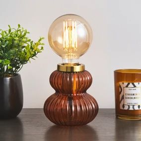 a table topped with a candle and a vase filled with plants