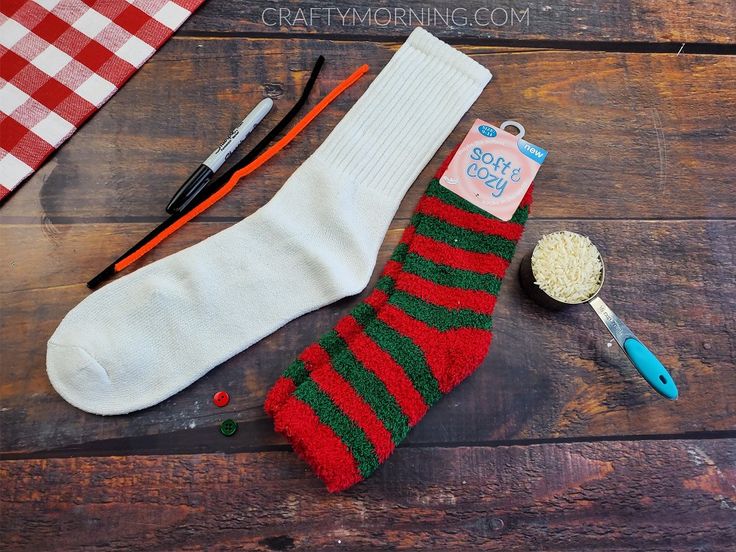 a pair of socks and some scissors on a wooden table with other crafting supplies