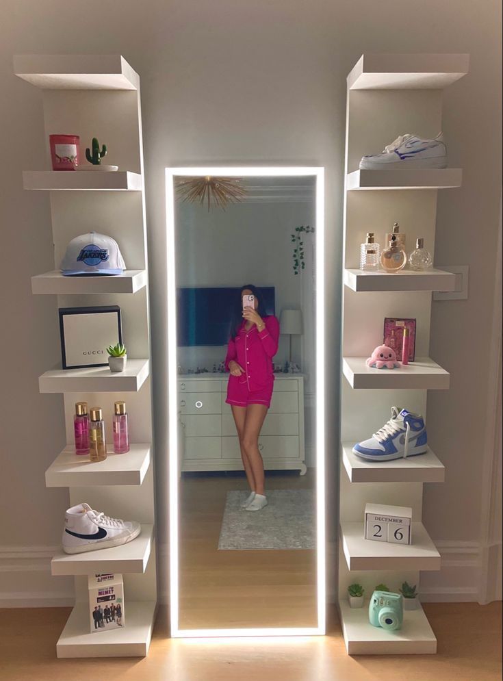 a woman standing in front of a mirror next to shelves filled with shoes and other items