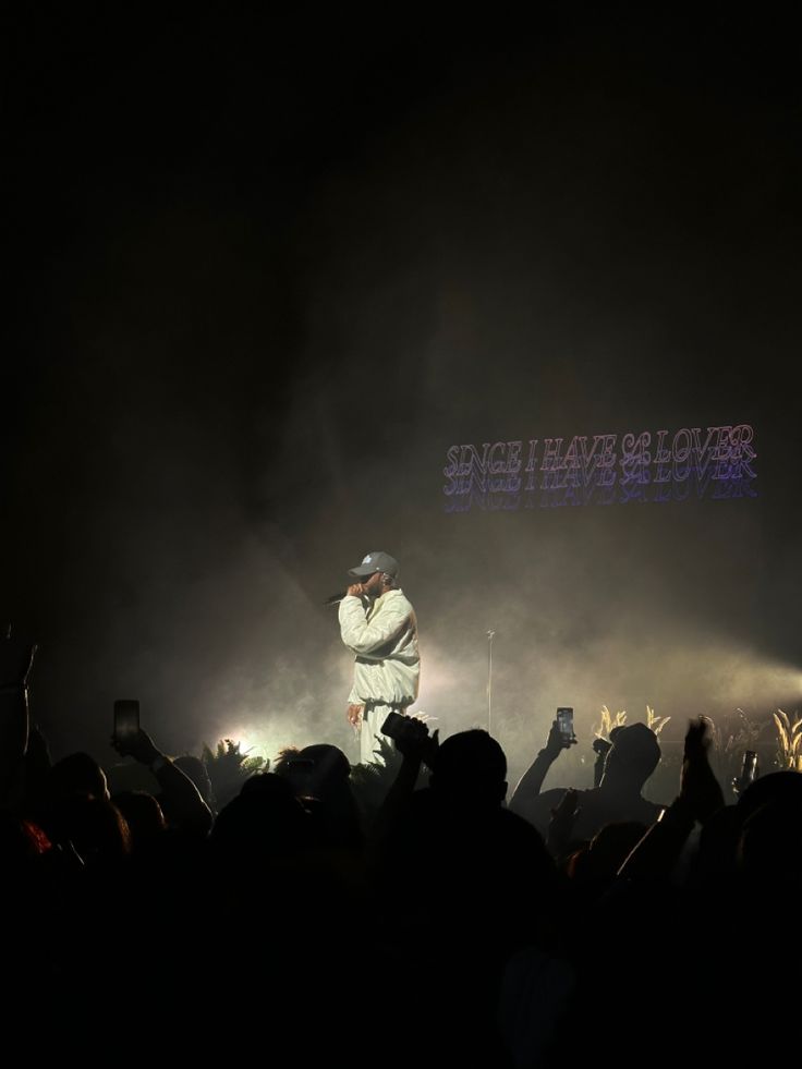 a man standing on top of a stage in front of a crowd