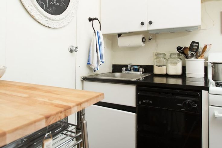 a kitchen with white cabinets and black counter tops