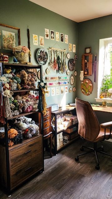 a room with a desk, chair and shelves full of items on the wall next to a window