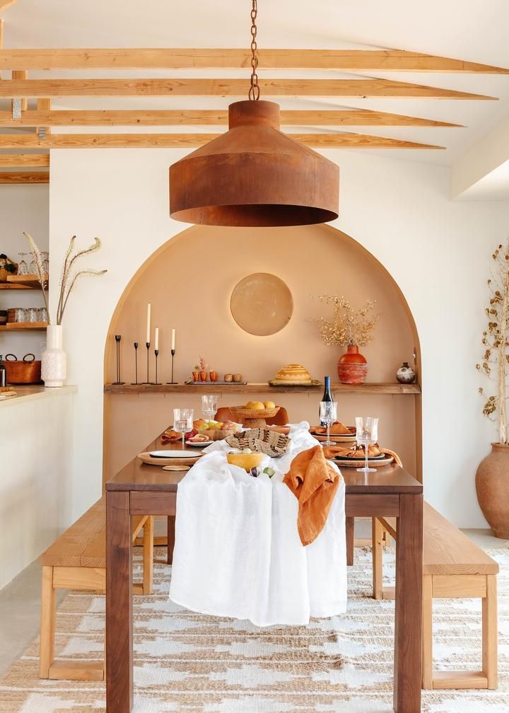 a dining room table with an oven in the back ground and food on top of it