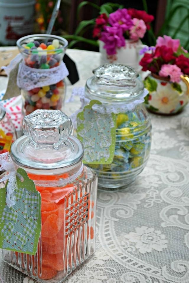 several glass jars filled with candy sitting on top of a table