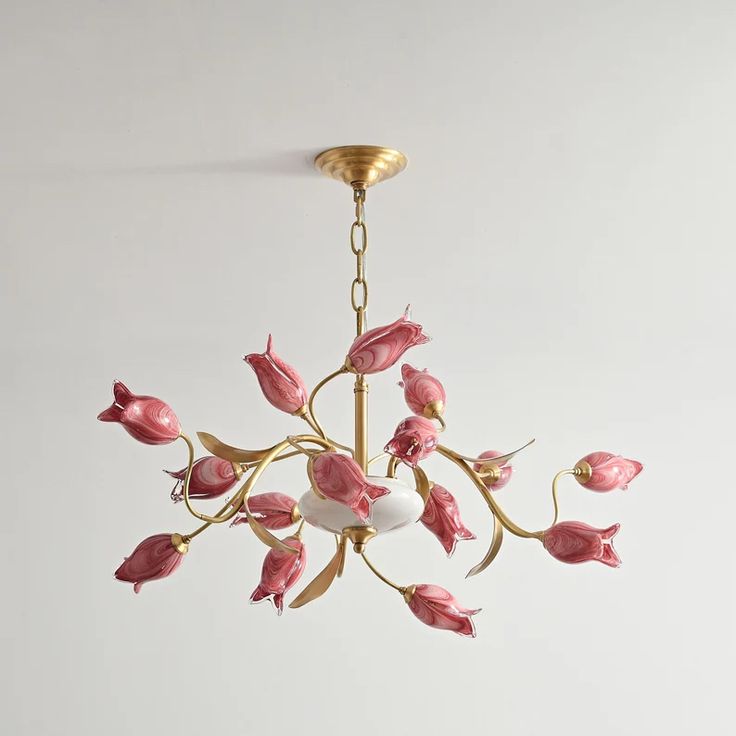 a chandelier with pink flowers hanging from it's center point, on a white wall