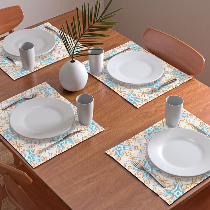 the table is set with place mats, plates and cups for two people to eat