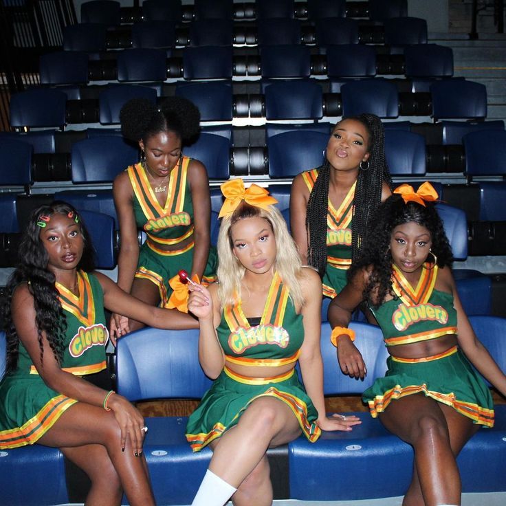 the cheerleaders are sitting on the bleachers and posing for a photo