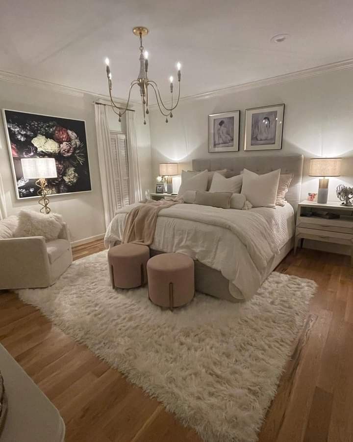 a bedroom with a large bed, two chairs and a chandelier