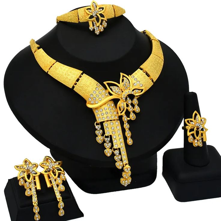 Indulge in luxury with this exquisite Necklace Set, perfect for wedding parties. With its opulent design and superior craftsmanship, this set features a necklace, bracelet, earrings, and ring. Make a lasting impression and elevate your style with this luxurious jewelry set." Elegant Plated Jewelry Sets For Party, Elegant Plated Wedding Jewelry, Elegant Plated Bridal Sets For Wedding, Elegant Gold Plated Bridal Sets For Anniversary, Fine Jewelry Sets With Jewels For Anniversary, Elegant Fine Jewelry Sets For Party, Wedding Jewelry Sets With Plated Cubic Zirconia, Party Diamond Plated Jewelry, Party Diamond-plated Jewelry