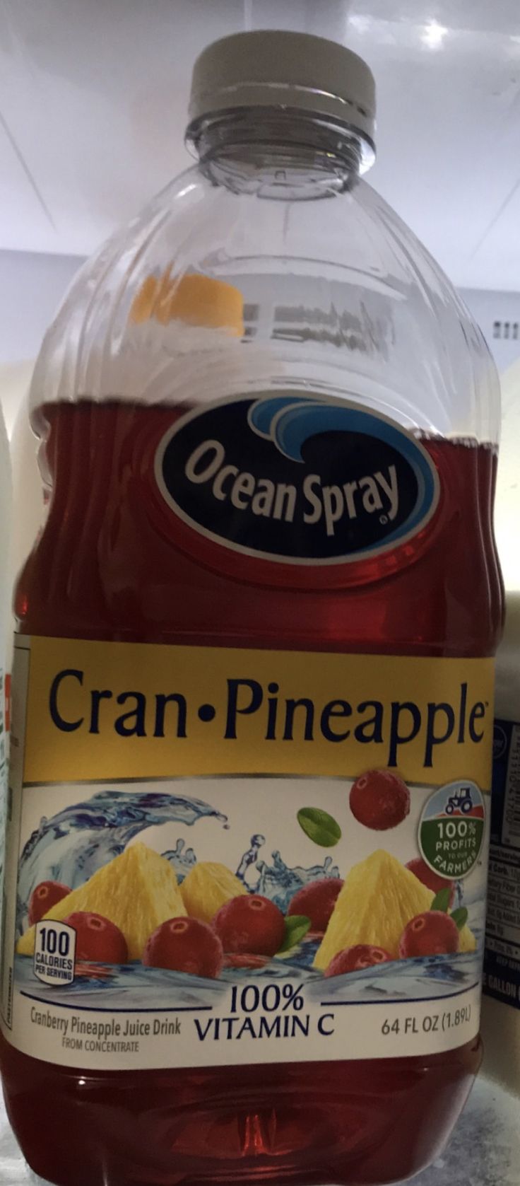 a bottle of cran - pineapple juice sitting on top of a refrigerator