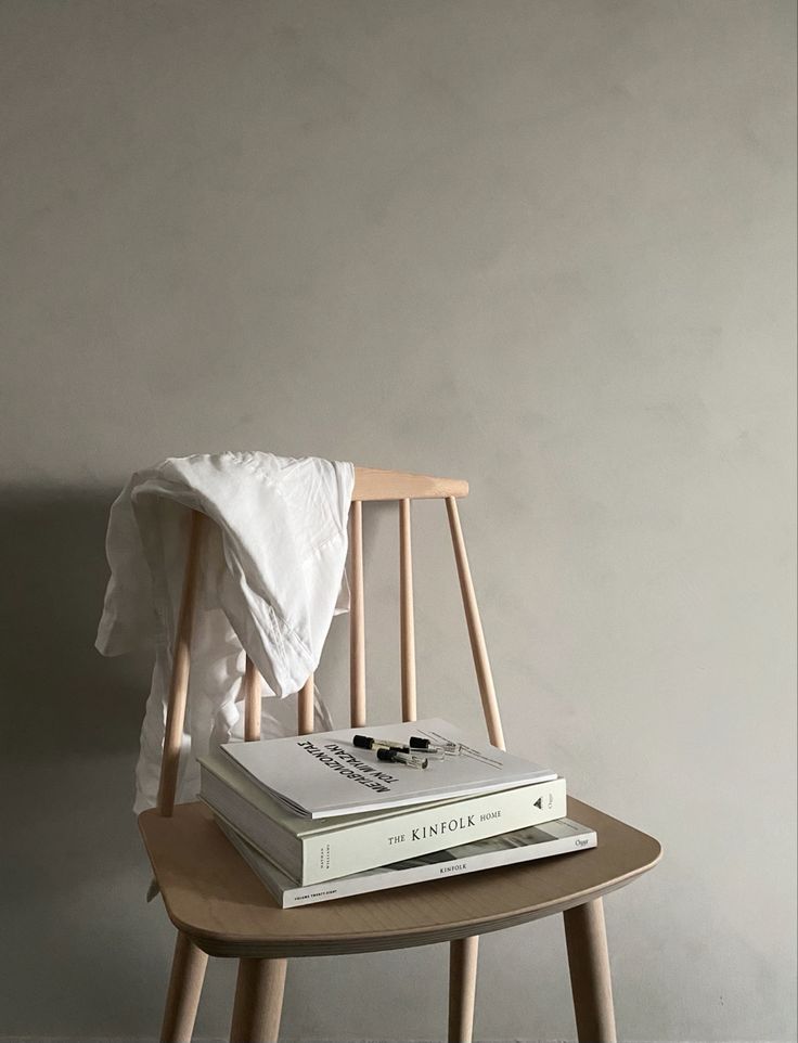 a stack of books sitting on top of a wooden chair