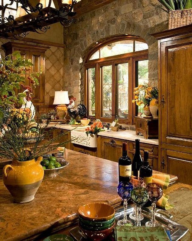 a kitchen filled with lots of counter top space next to a large stone wall mounted oven