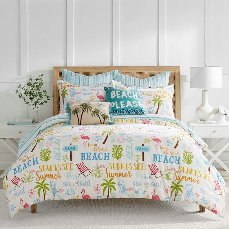 a bed with colorful comforters and pillows on it