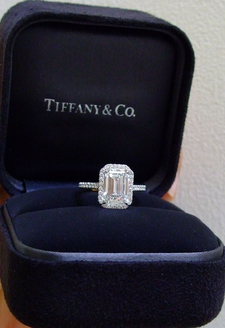 an engagement ring in a velvet box with the word tiffany & co on it's side