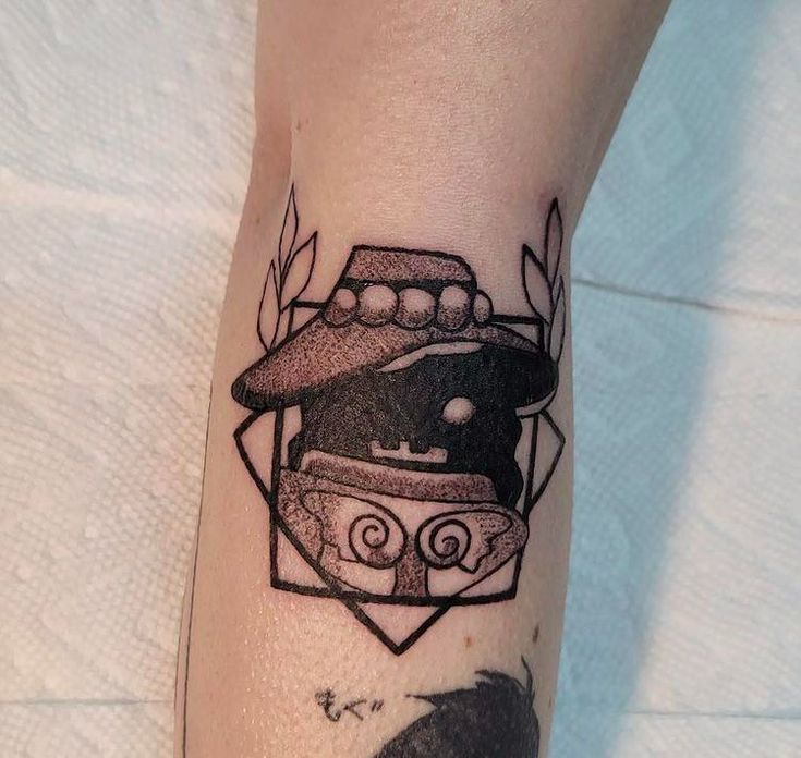 a black and white photo of a tattoo with a car in the center on someone's leg