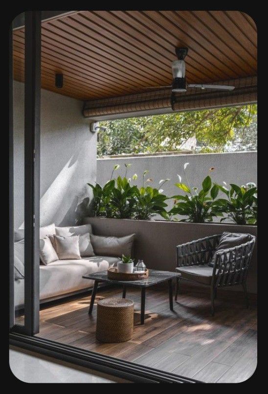 an outdoor living area with couches, tables and potted plants on the deck