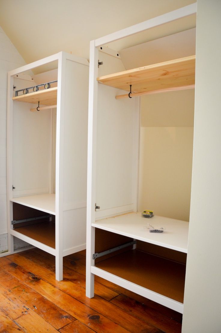 two white closets with wooden floors in an empty room