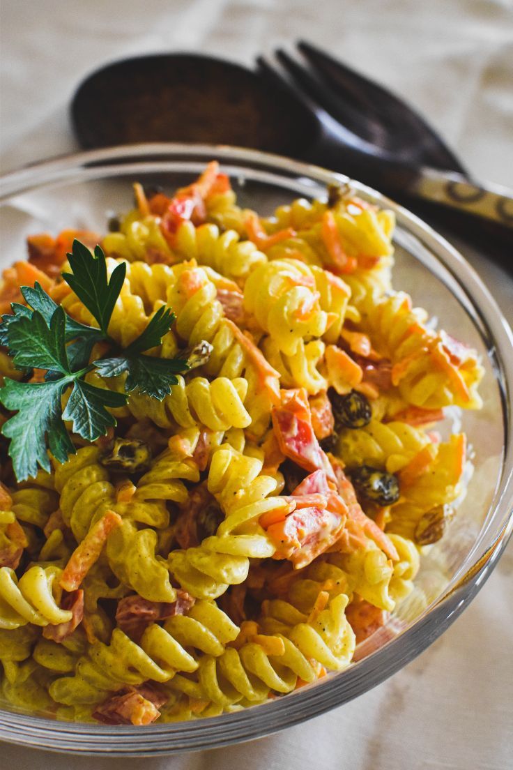 a bowl filled with pasta and vegetables on top of a table