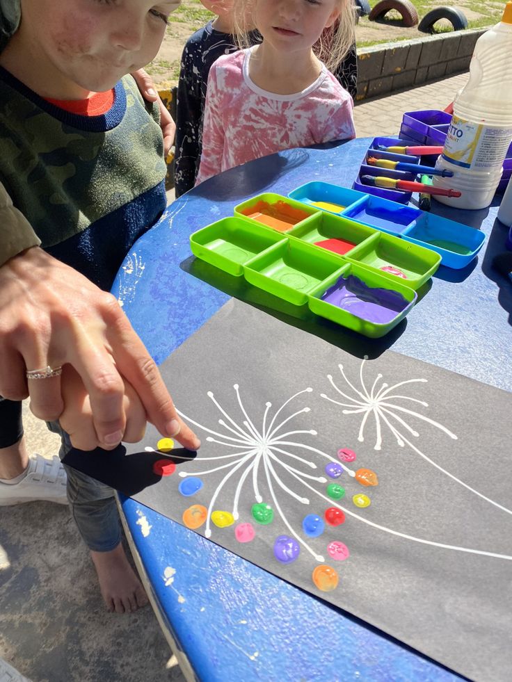 two children are sitting at a table with their hands on the board