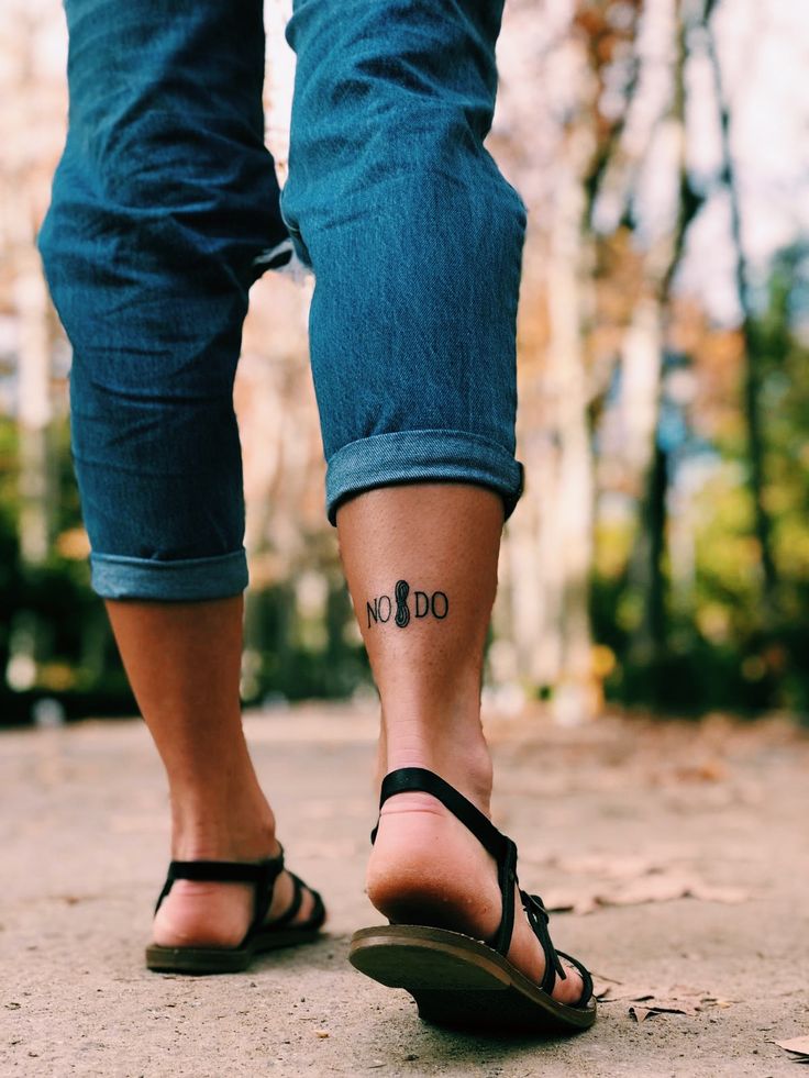 a woman's foot with the word do not go tattooed on her left ankle