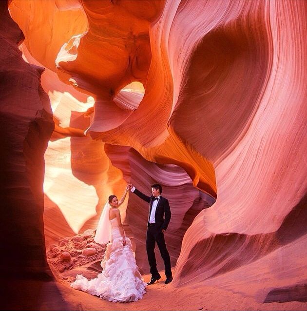 a bride and groom standing in the middle of a slot at antelope canyon