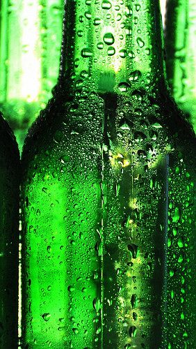 several green bottles with water droplets on them