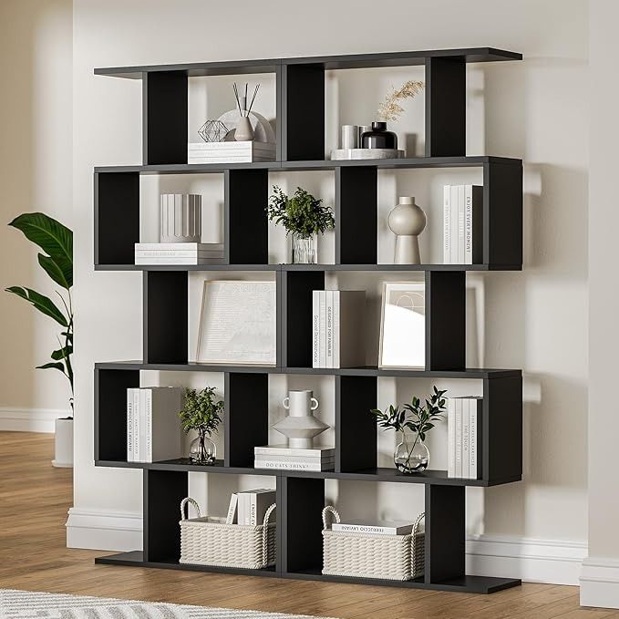 a black and white book shelf filled with lots of books next to a wall mounted plant