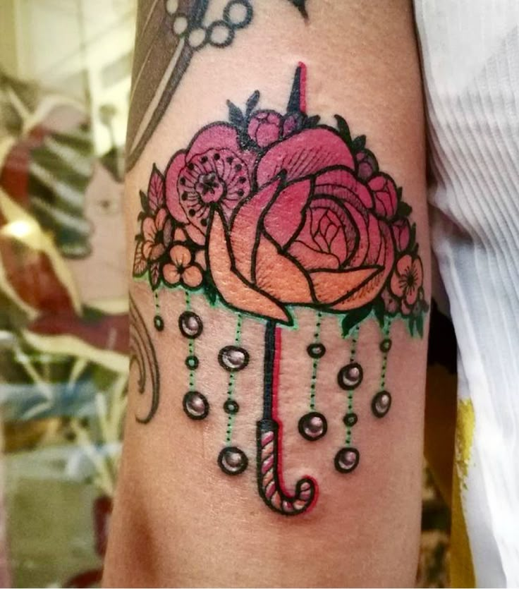 a woman's arm with an umbrella and flowers on it