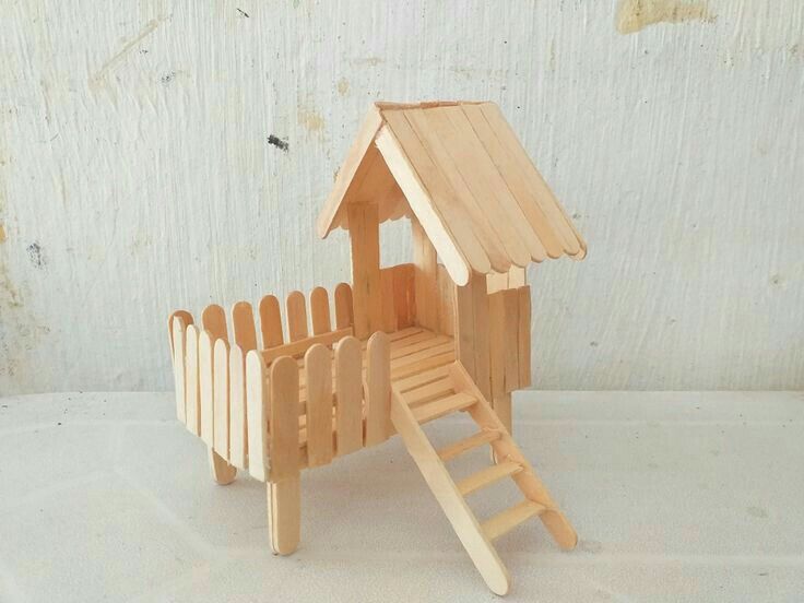 a wooden toy house with a ladder to the roof