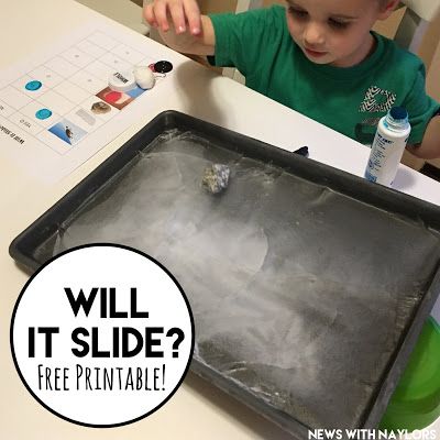 a young boy sitting at a table with a black tray on it that has ice in it