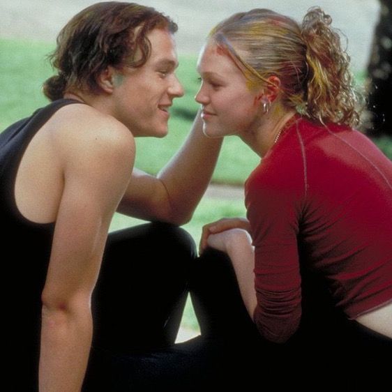 two young women sitting next to each other on the ground looking into each others eyes